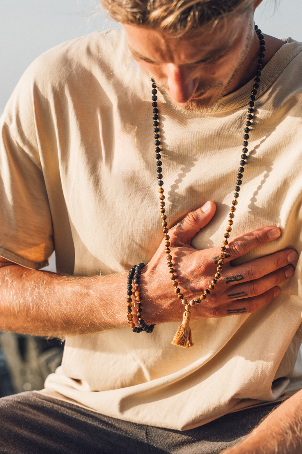Mann trägt Armbänder aus Tigerauge echten Edelsteinen
